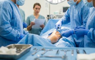 Surgeons preparing a patient leg for an emergency fasciotomy procedure in a hospital.