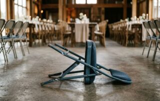 A broken metal folding chair with a bent leg on a concrete floor.