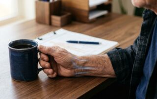 Veteran’s hand gripping a mug with subtle blue nerve highlights.