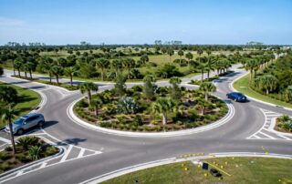 Two cars navigate a Florida roundabout beside roadside crash evidence.