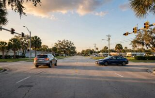 A sedan makes a U-turn as another car brakes at a Florida intersection.