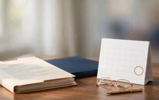 An organized veterans appeal file with a calendar, glasses, and pen on a wooden desk.